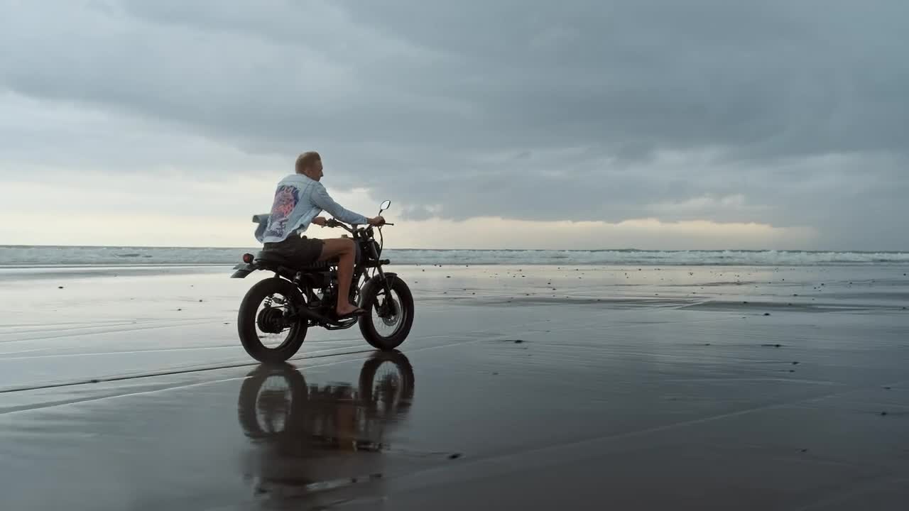 Download Stock Video Man Riding Motorcycle On The Beach On A Cloudy Da Animated Wallpaper