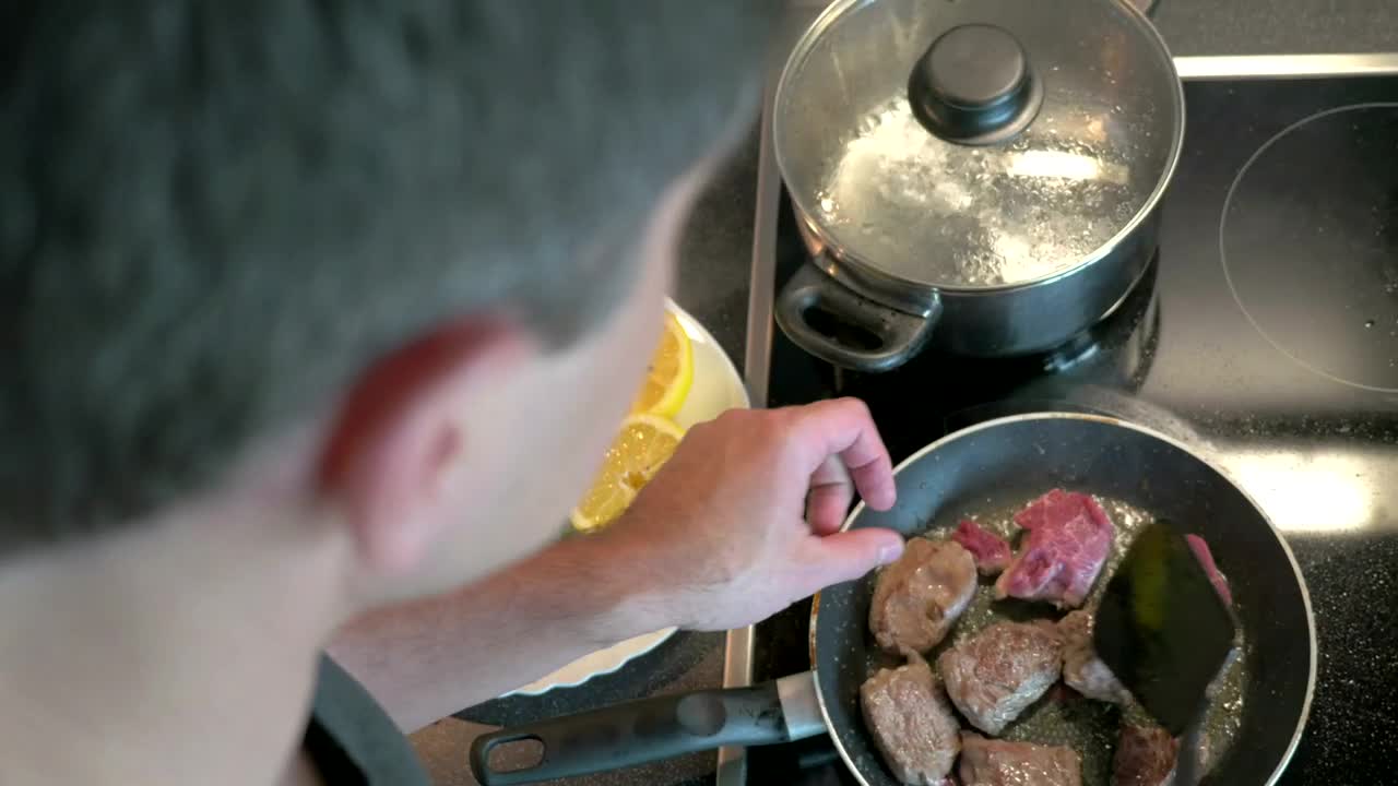 Download Stock Video Man Preparing Beef In A Frying Pa Animated Wallpaper