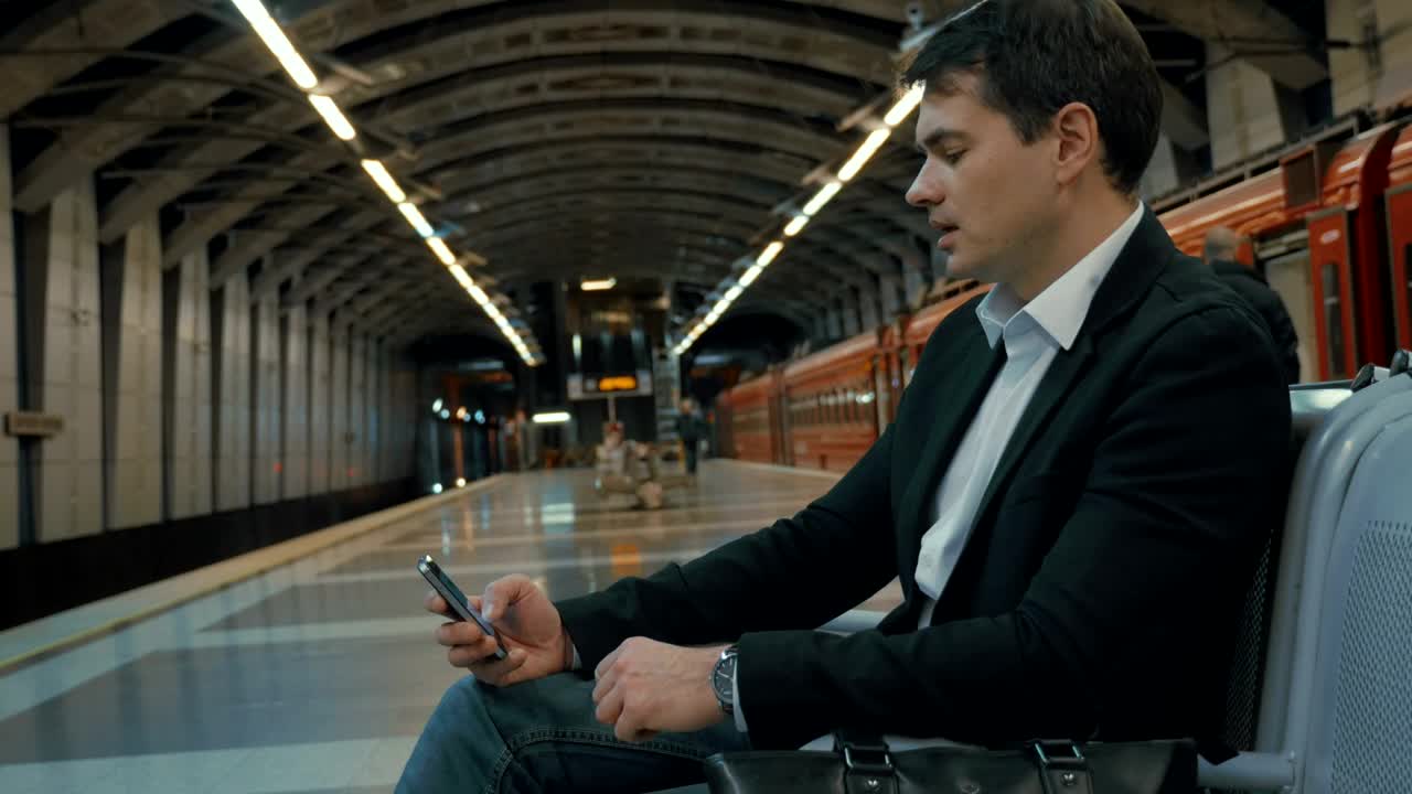 Download Stock Video Man On His Phone Waiting For A Trai Animated Wallpaper