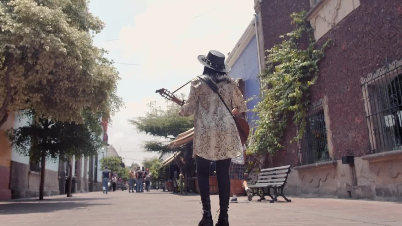 Download Stock Video Mujer Caminando Por Una Calle Colonial Mientras Toca Su Guitarra Live Wallpaper