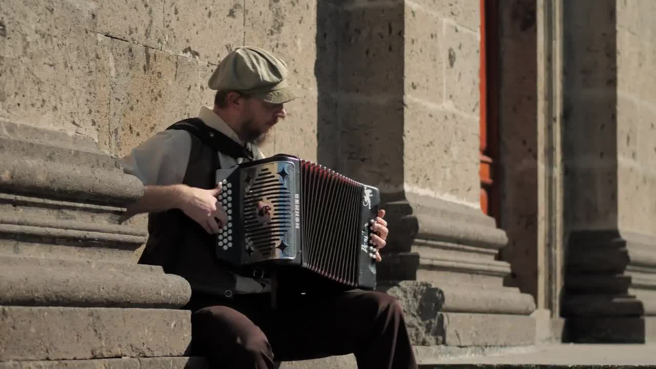 Download Stock Video Musician Playing Accordion In Front Of A Concrete Building Live Wallpaper