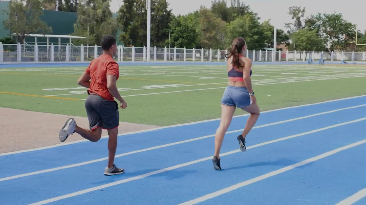 Download Stock Video Pair Of Man And Woman Athletes Running On A Track Live Wallpaper