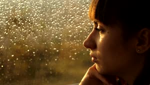 Download Stock Video Pensive Woman Looking Out Of A Window On A Rainy Live Wallpaper