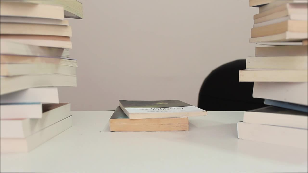 Download Video Stock Person Sits Down To Read Surrounded By Many Books Live Wallpaper Free