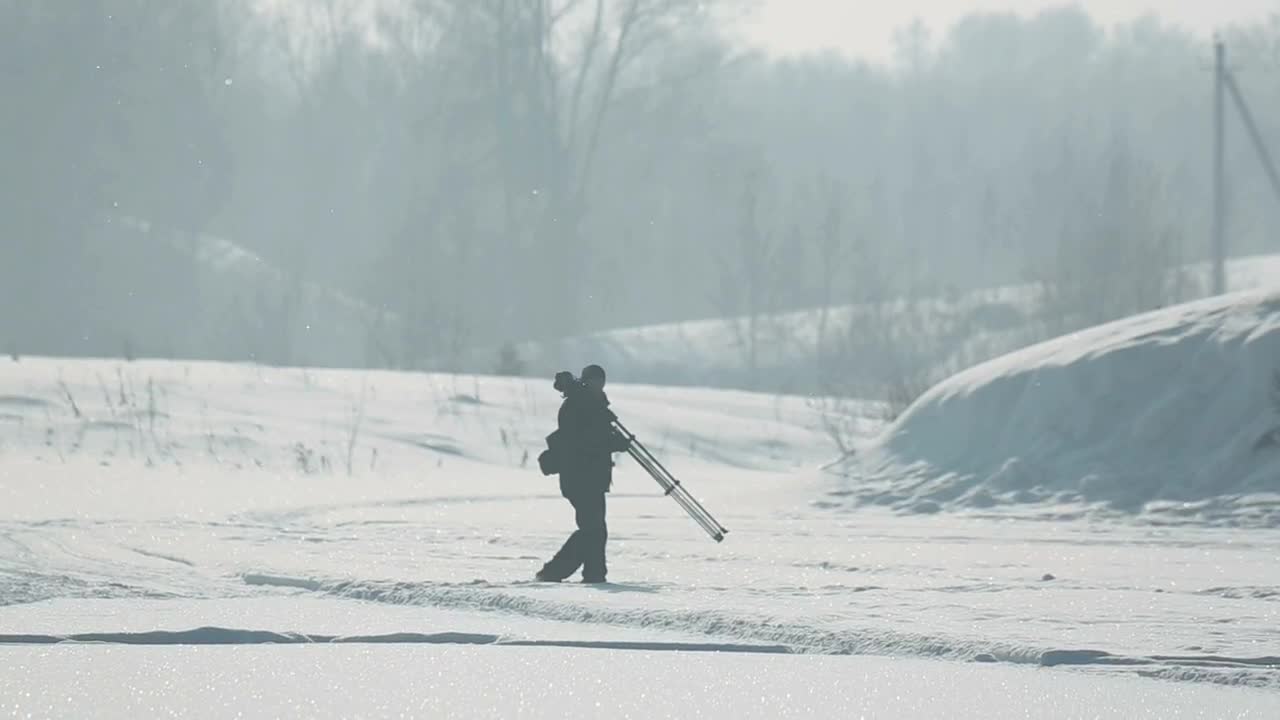 Download Video Stock Photographer Carring A Tripod In The Snow Live Wallpaper Free