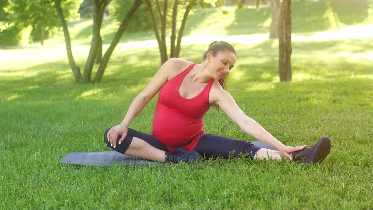 Download Video Stock Pregnant Woman Does Stretching On The Grass Live Wallpaper Free