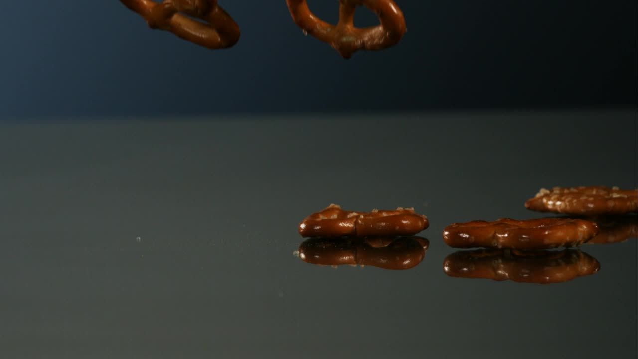 Download Video Stock Pretzels Falling Into A Mirror Surface Live Wallpaper Free