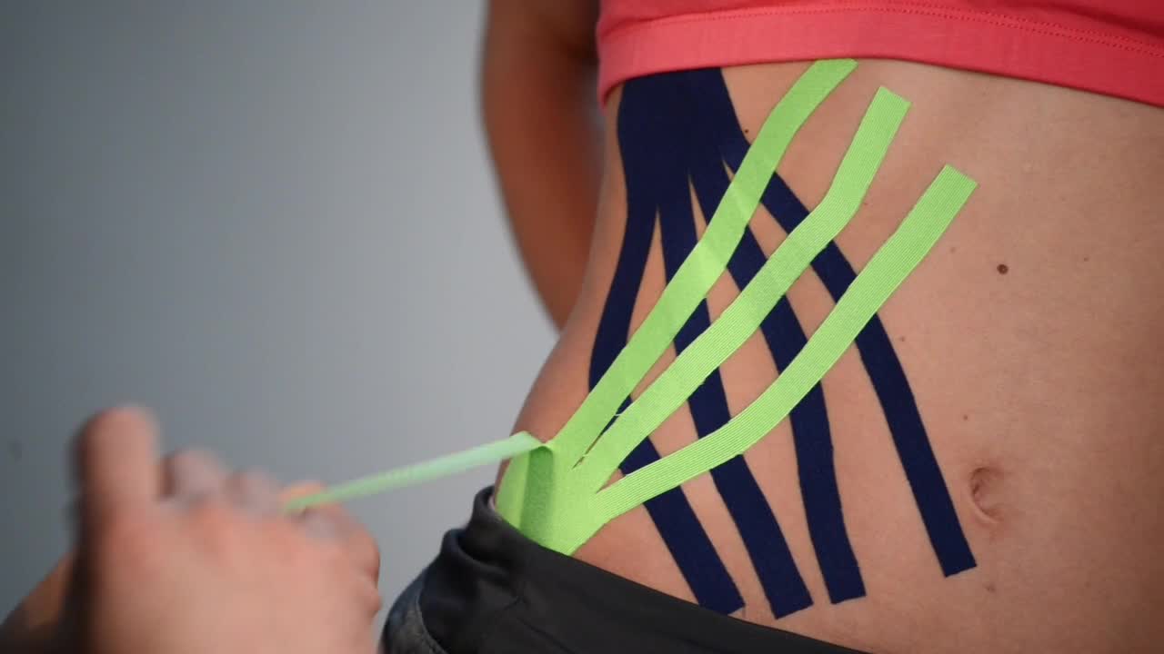 Download Video Stock Putting Kinesio Tape On An Athletes Hip Live Wallpaper Free