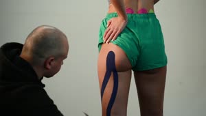 Download Video Stock Putting Kinesio Tape On The Leg And Gluteus Of An Live Wallpaper Free