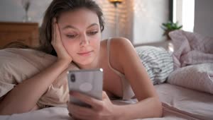 Download Free Stock Video Relaxed Woman On Bed Looking At Her Smartphone Live Wallpaper