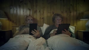 Download Free Stock Video Senior Couple Reading On The Bed With Devices Live Wallpaper
