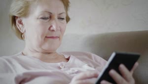 Download Free Stock Video Senior Woman Looking At Reading Device Live Wallpaper