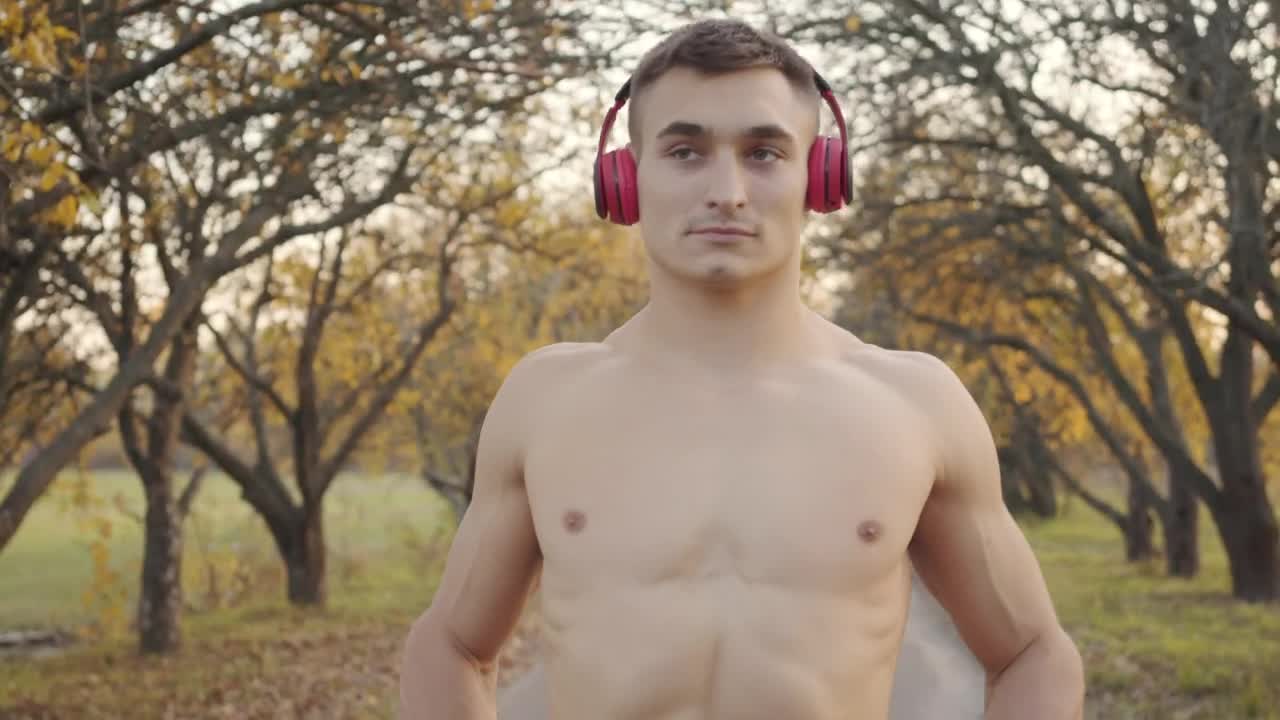 Download Free Stock Video Shirtless Man In Headphones Flexes Muscles Before Outdoor Workout Live Wallpaper