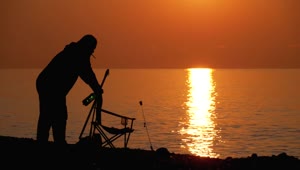 Download Free Stock Video Silhouette Of A Man Preparing Chair To Fish Live Wallpaper