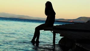 Download Free Stock Video Silhouette Of Woman Putting Her Feet Into The Sea Live Wallpaper