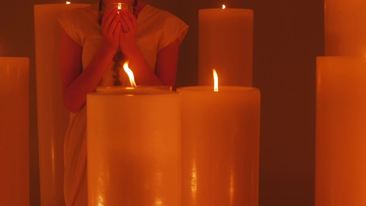 Download Free Video Stock Spiritual Woman Meditating Among Many Candles Live Wallpaper