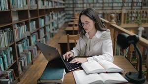 Download Free Video Stock Student Doing Research In University Library With Books And Laptop Live Wallpaper