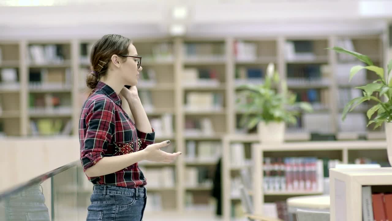 Download Free Video Stock Student Woman Talking On The Phone In The Library Live Wallpaper