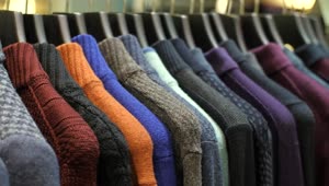 Download Free Video Stock sweaters hanging on the coat rack of a clothing store Live Wallpaper