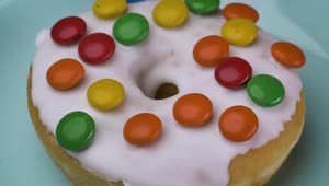 Download Free Video Stock taking glazed donut with colored chocolates from a plate Live Wallpaper