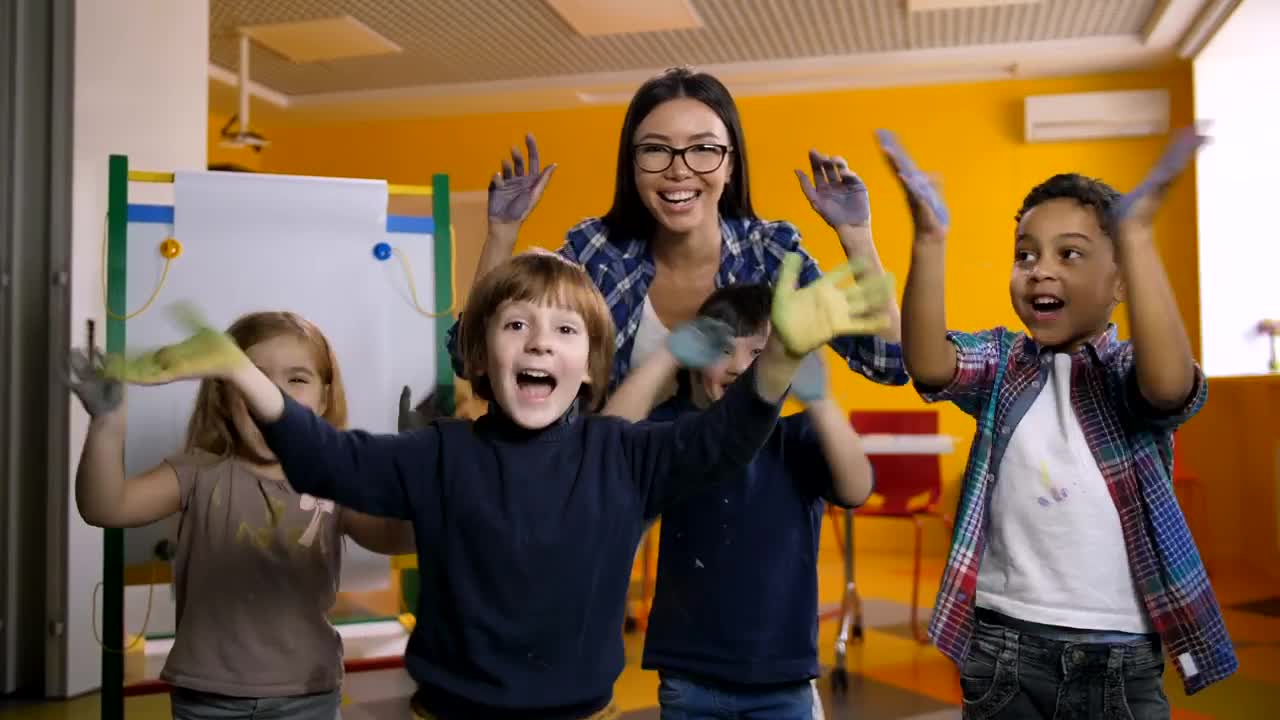 Download Free Video Stock teacher and students waving with painted hands Live Wallpaper