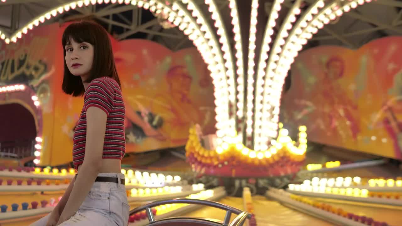 Download Free Video Stock teenage woman sitting in a mechanical fair game with the Live Wallpaper