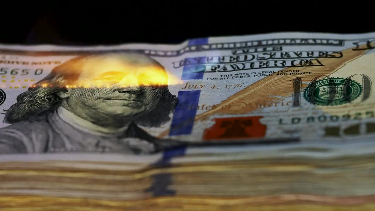 Download Free Video Stock tower of  dollars being burned with a flame Live Wallpaper