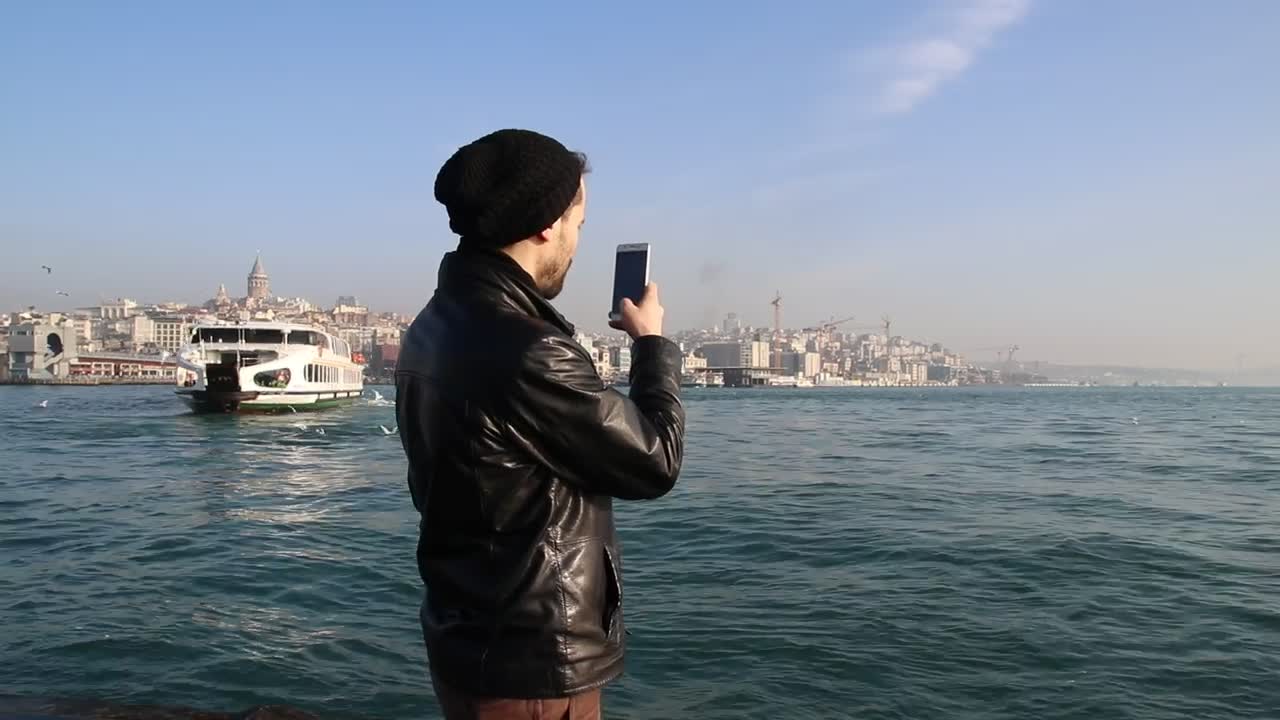 Download Free Stock Video Young Man Taking Photos On A Sunny Shore Live Wallpaper