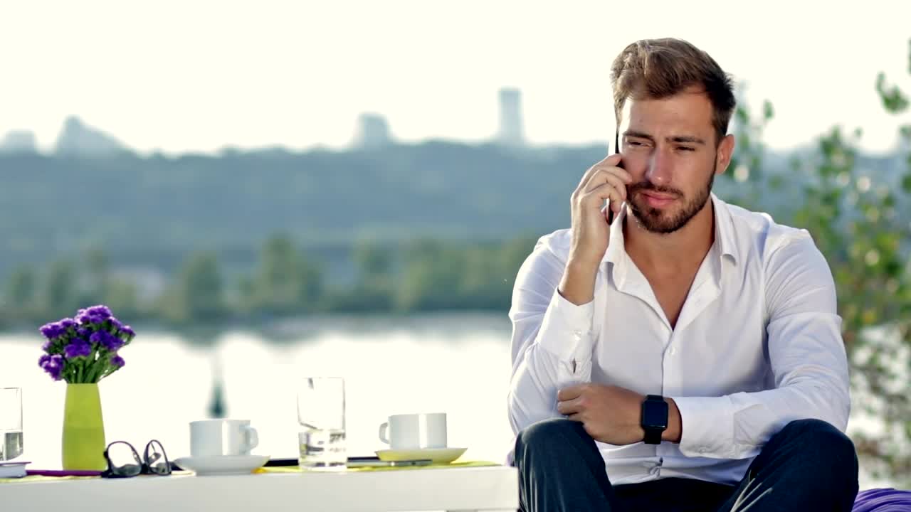 Download Free Stock Video Young Man At A Table Outdoors On A Call Live Wallpaper