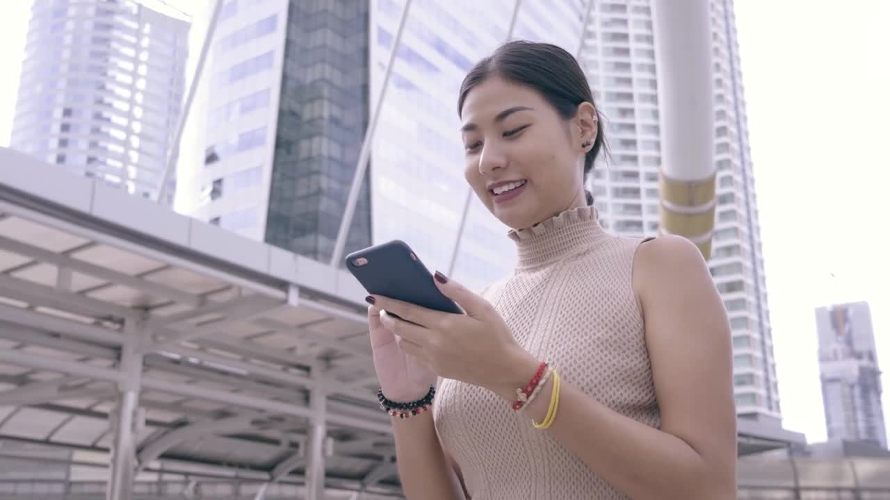 Download Free Stock Video Woman Using Her Cell Phone While Walking Through A City Live Wallpaper