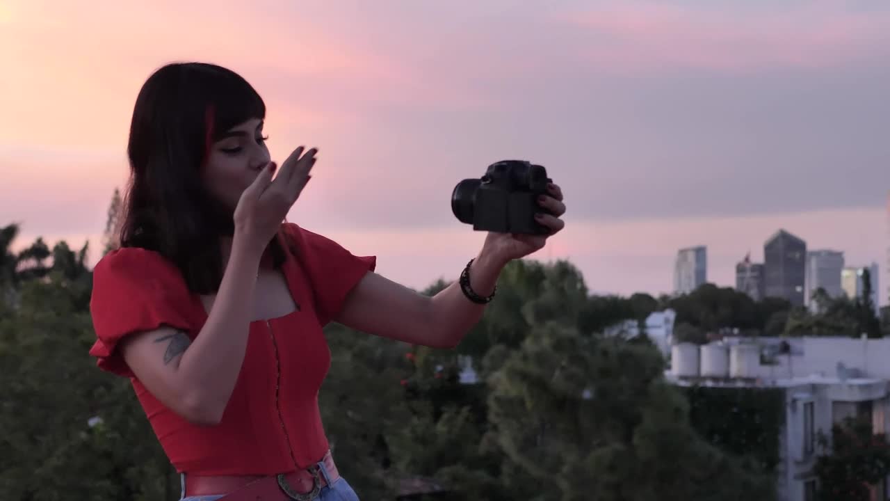 Download Free Stock Video Woman Shooting A Blog With City Background At The Sunset Live Wallpaper