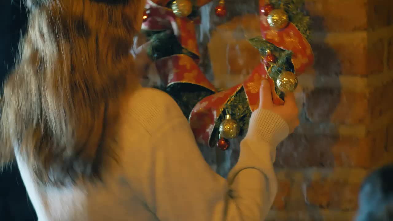 Download Free Stock Video Woman Placing A Christmas Wreath On A Wall In Her Live Wallpaper