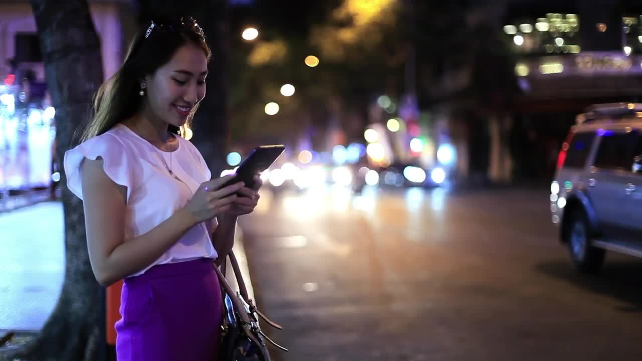 Download Free Stock Video Woman On The Street Sending Messages At Night Live Wallpaper