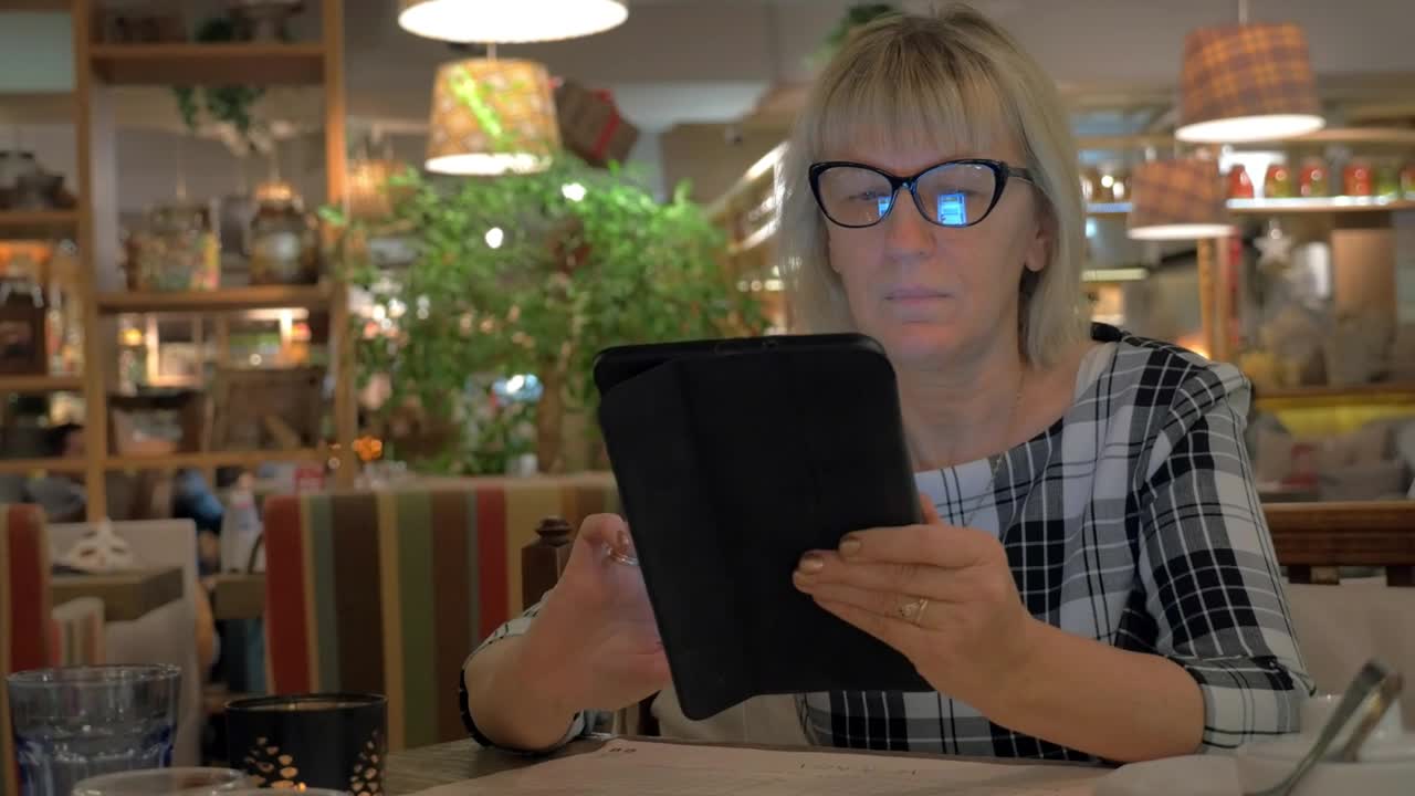 Download   Stock Footage Woman Browsing A Tablet Before Ordering Live Wallpaper