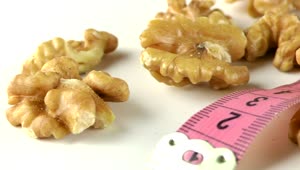 Download   Stock Footage Walnuts And Measure Tape On White Table Live Wallpaper