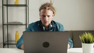 Download   Stock Footage Urban Man Browses Web On Laptop With Headphones Live Wallpaper