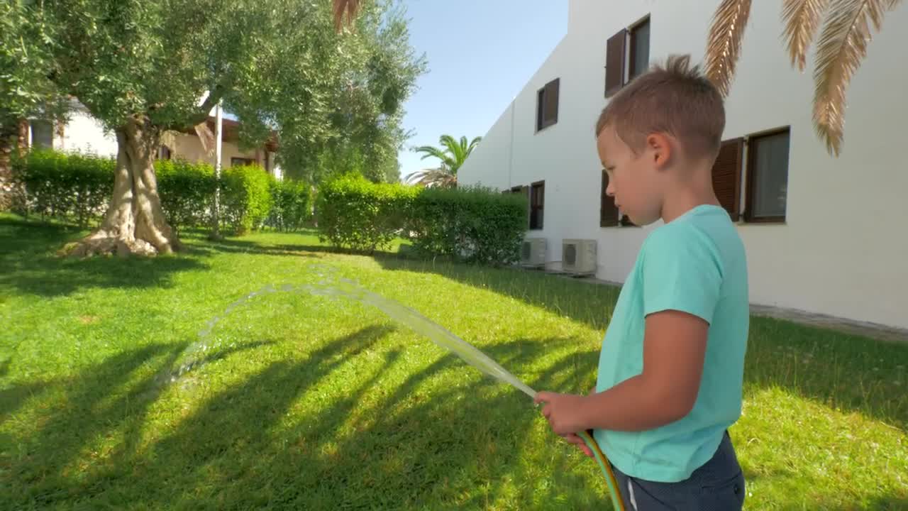 Download Stock Footage Young Boy Watering Grass Live Wallpaper Free