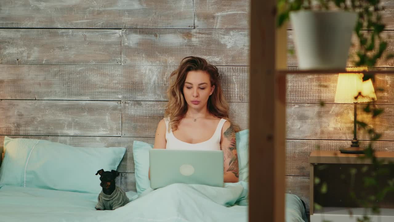 Download Stock Footage Woman Working From Her Bed With Her Pet Live Wallpaper Free