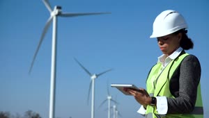 Download Stock Footage Woman Using A Tablet In A Wind Turbine Field Live Wallpaper Free