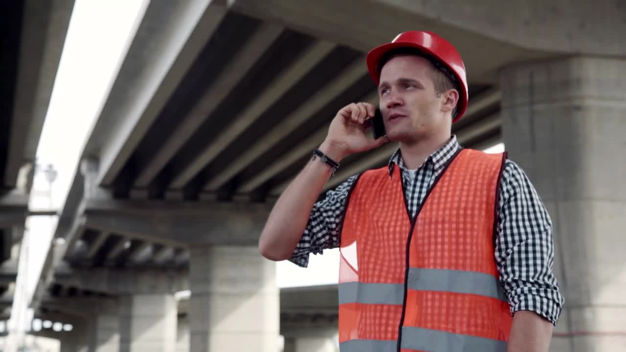 Download Stock Footage Young Construction Worker Talking On The Phone Live Wallpaper Free