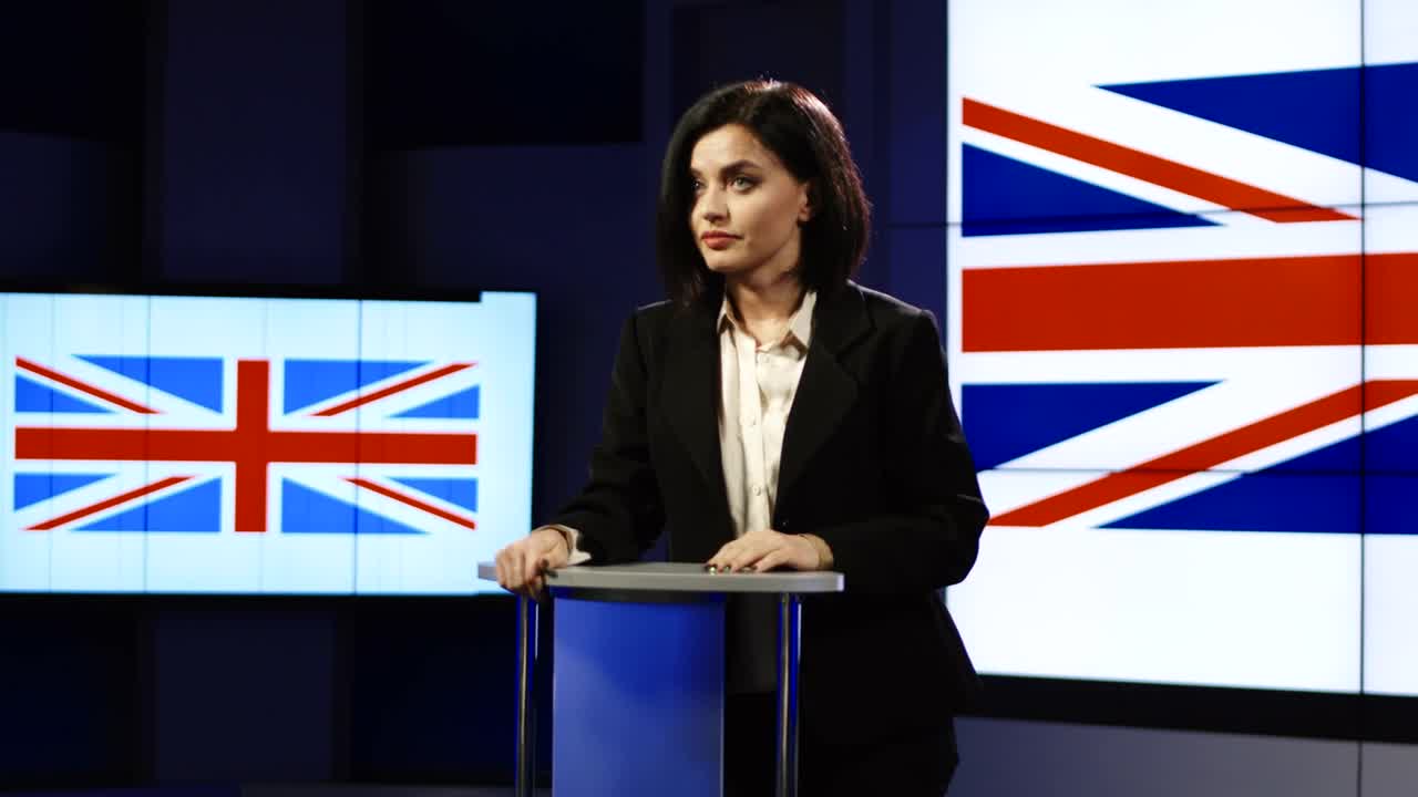 Download Stock Footage Young Woman Speaking With Uk Flag Behind Her Live Wallpaper Free