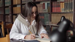 Download Stock Footage Woman Writing Her Homework In The Library Live Wallpaper Free
