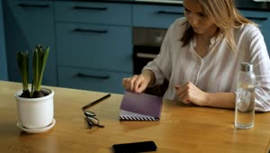 Download Stock Footage Young Woman Writing On A Notebook In The Kitchen Live Wallpaper Free