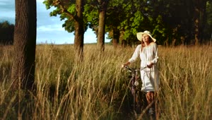 Download Stock Footage Woman Walking Bicycle Through Field Enjoys Afternoon Sun Live Wallpaper Free