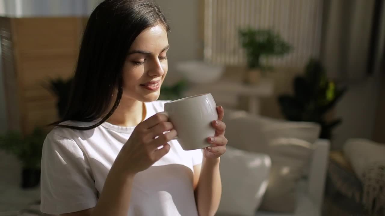 Download Stock Footage Woman Enjoys Cup Of Coffee And Smiles Live Wallpaper Free