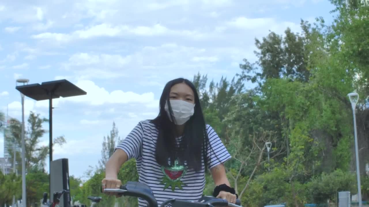 Download Stock Footage Woman With Mask On Bicycle In A Park Live Wallpaper Free