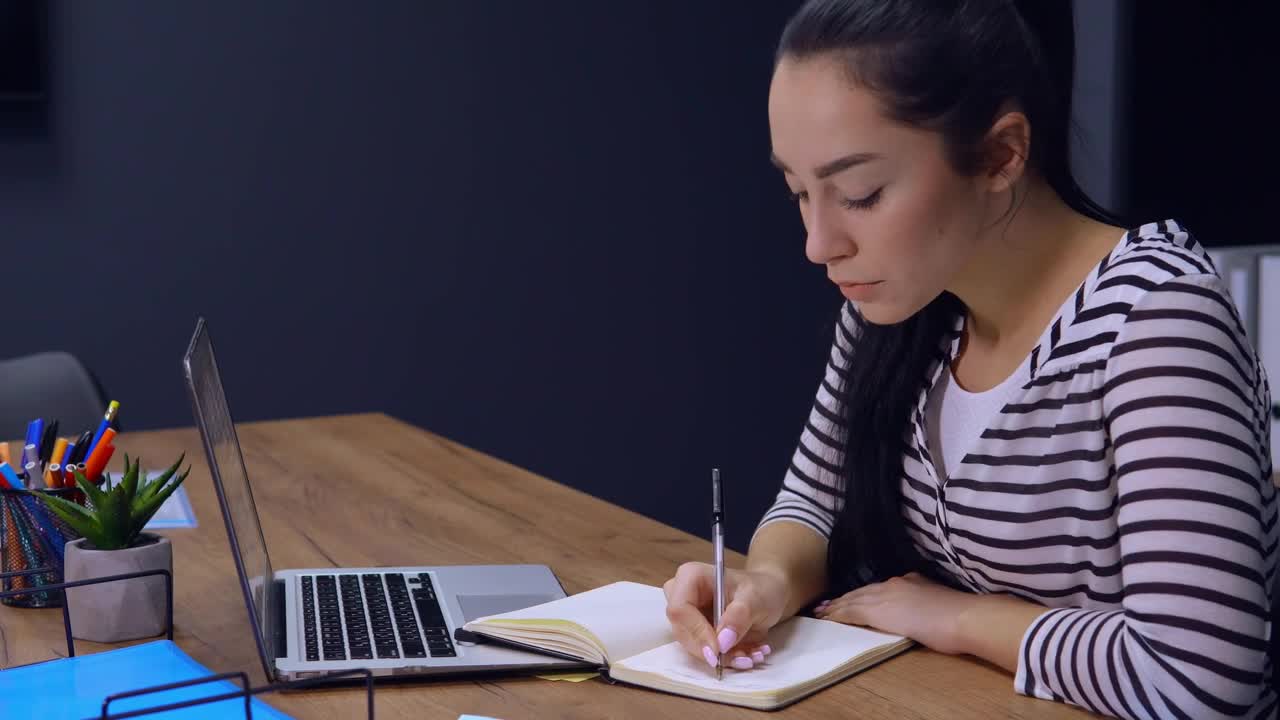 Download Stock Footage Young Woman Writes A List On Her Work Schedule Live Wallpaper Free